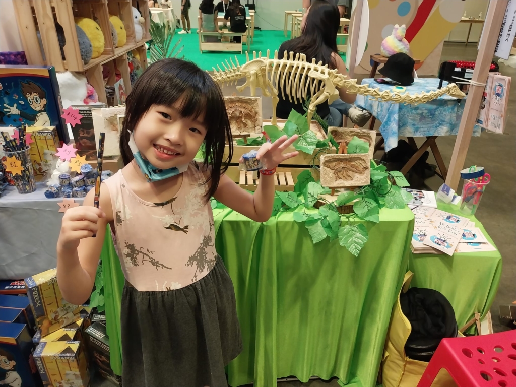 A happy kid in front of our dinosaur themed decor